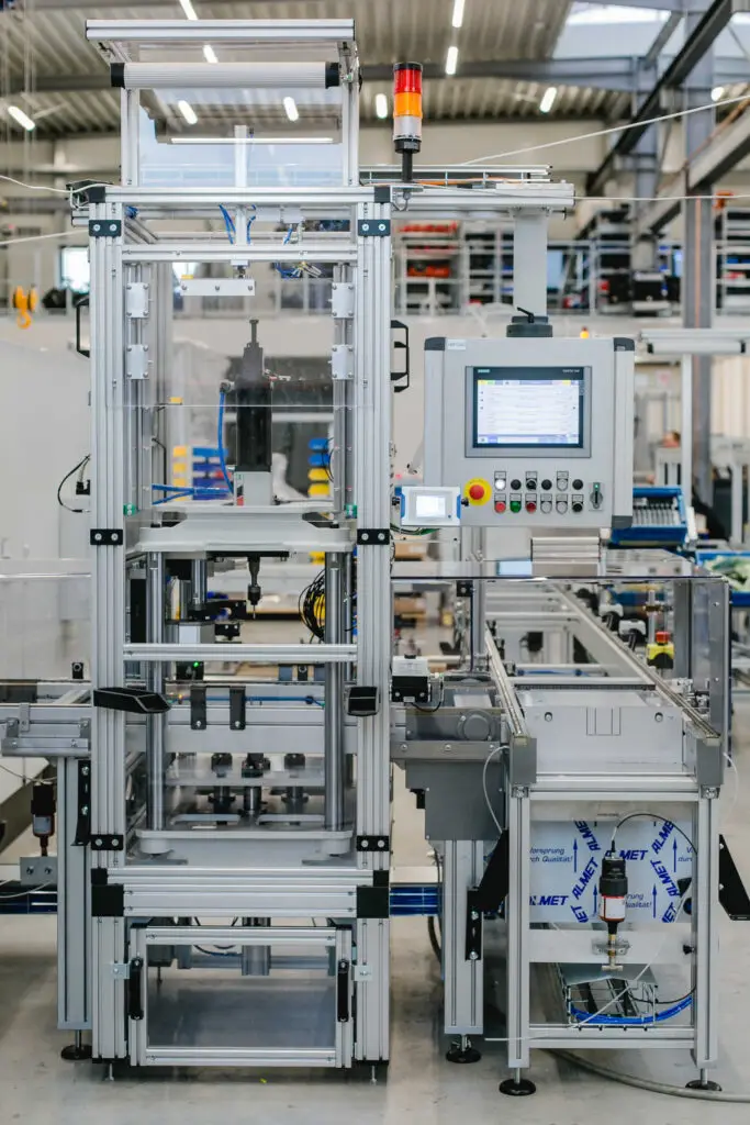Detailansicht einer Montage- und Prüfstation der Differentialmontagelinie von Ralf Lang Maschinenbau GmbH mit eingehaustem Prozessbereich und Bedienpanel