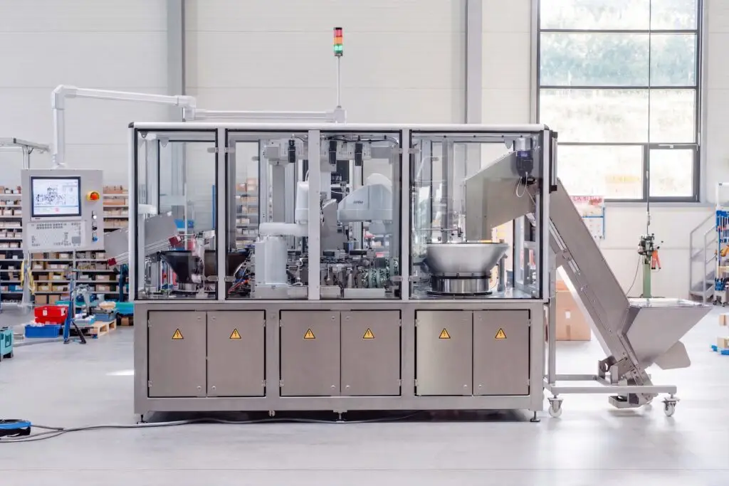 Rückansicht der Montage- und Prüfanlage für medizinische Bauteile mit automatischer Zuführung und integrierter Prüftechnik