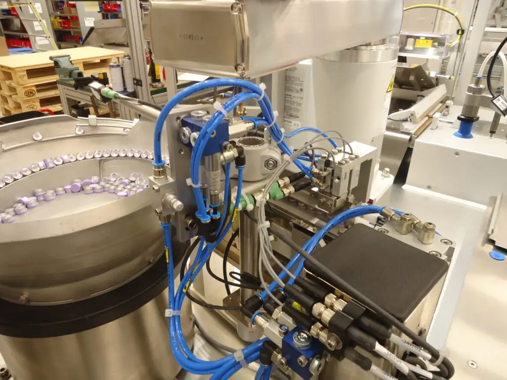 Detailansicht im Inneren der Verpackungsmaschine mit automatisiertem Handling und Verpackungsprozess für medizinische Komponenten